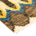 Close-up of a patterned carpet: geometric cuts, blues, yellows, browns.