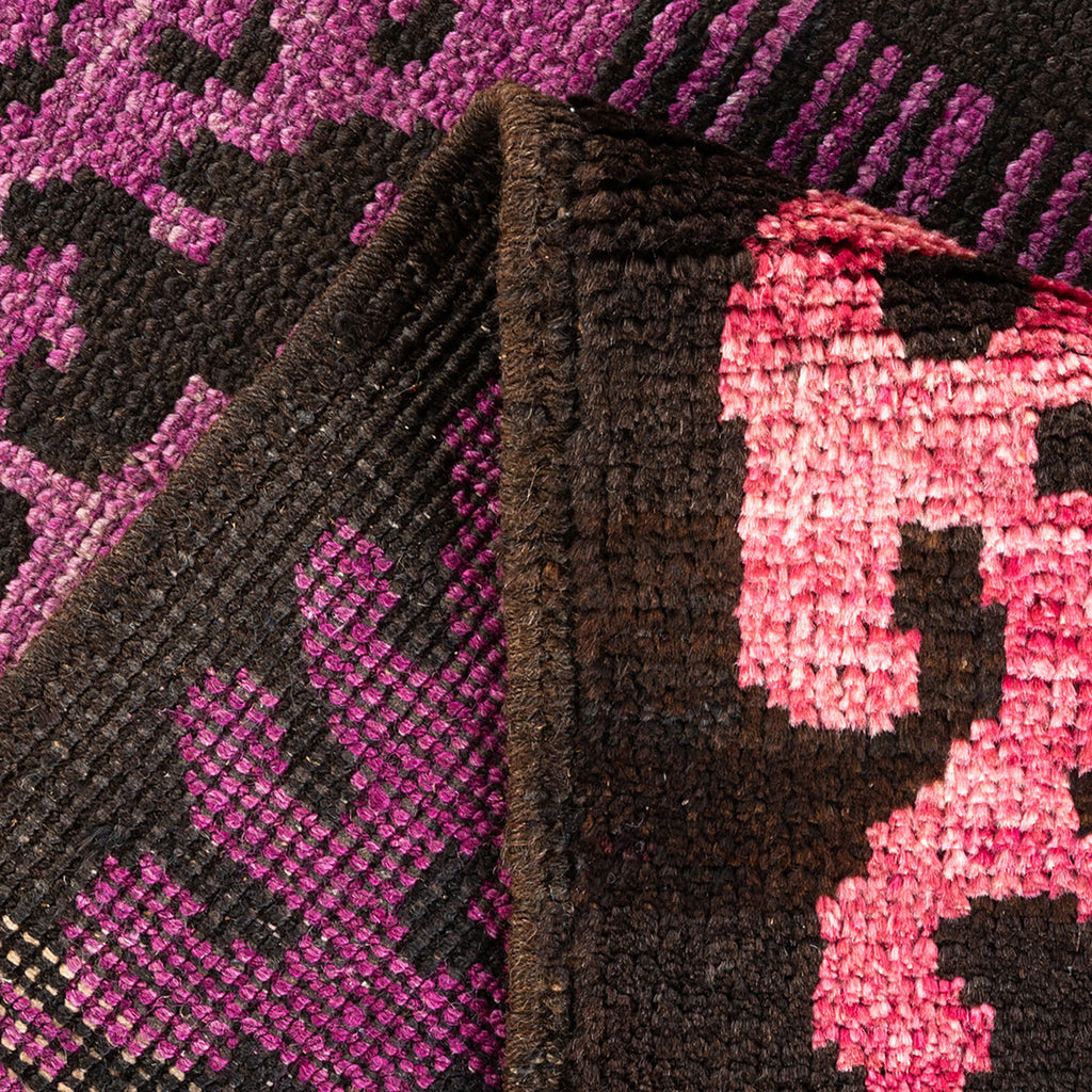 Close-up view of a thick, textured, geometric rug in brown and pink.