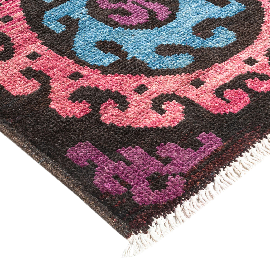 Vibrantly colored, intricate rug with floral patterns and fringe detail.