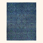 Intricate, symmetrical blue pattern resembling fabric designs with green accents.