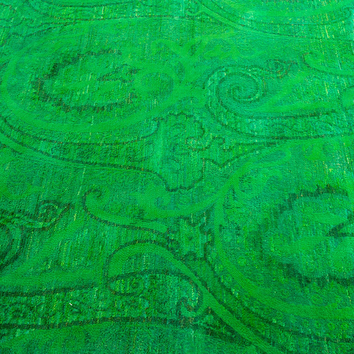 Vibrant green textured fabric with intricate floral-like designs.