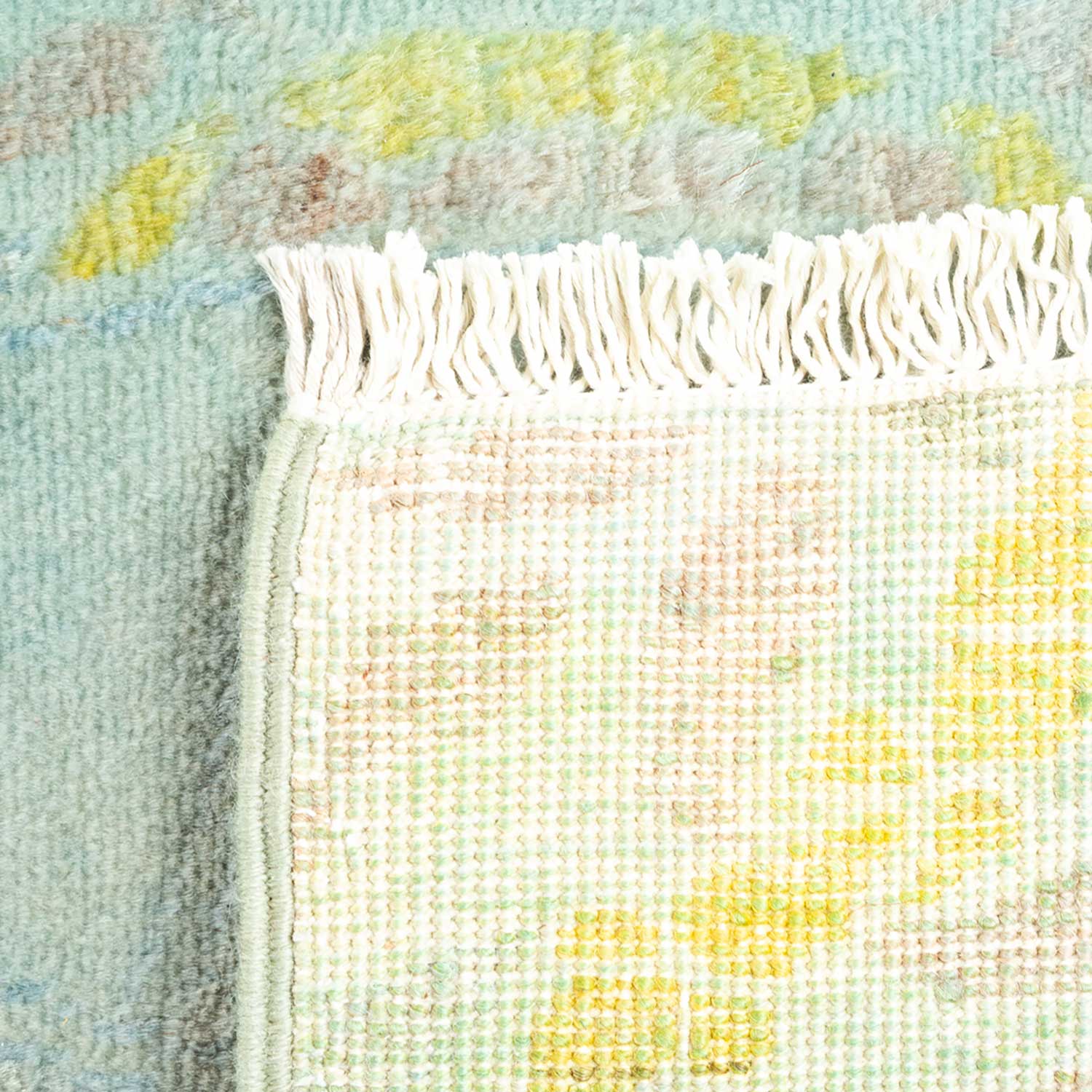 Close-up view of colorful woven fabric and blurred abstract pattern.
