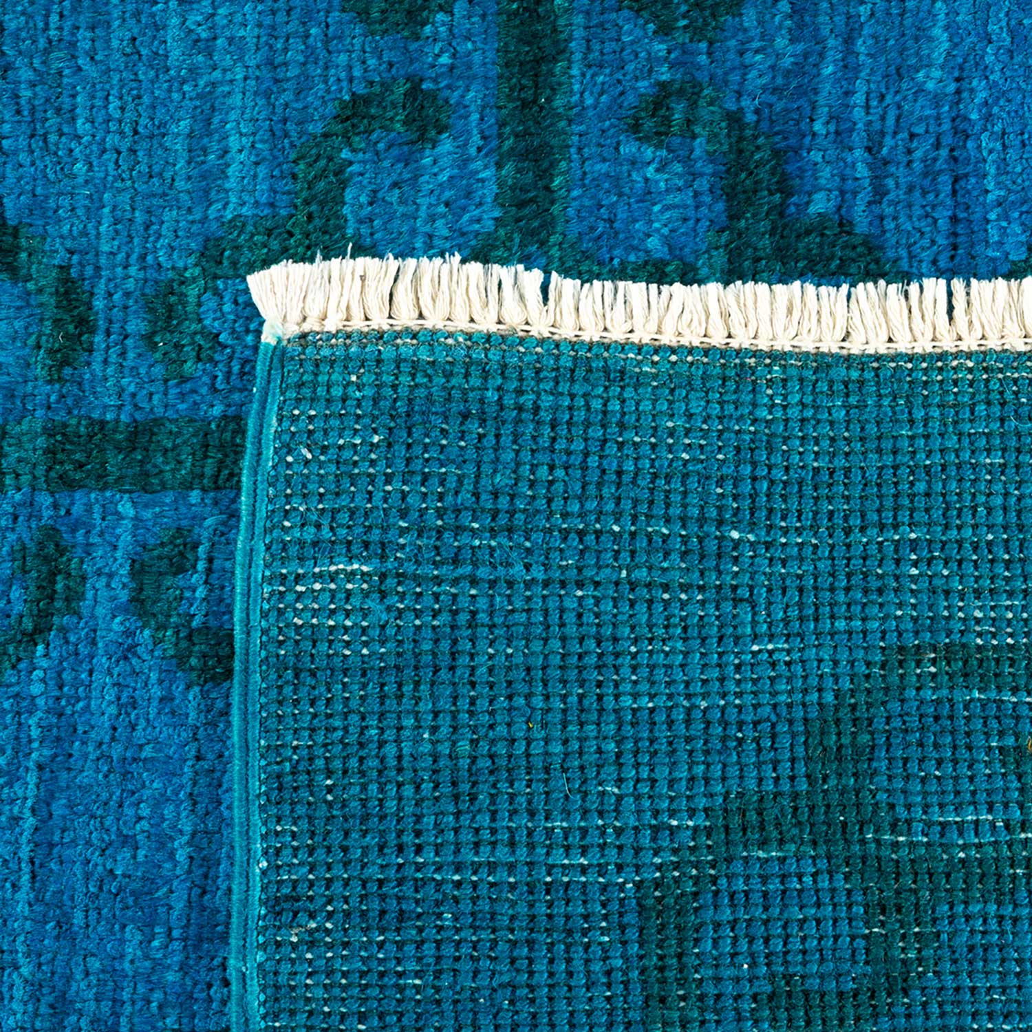 Close-up shot of a vibrant teal textured fabric with fringe.