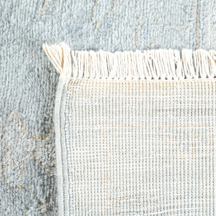 Close-up of a woven textile with contrasting textures and fringe.