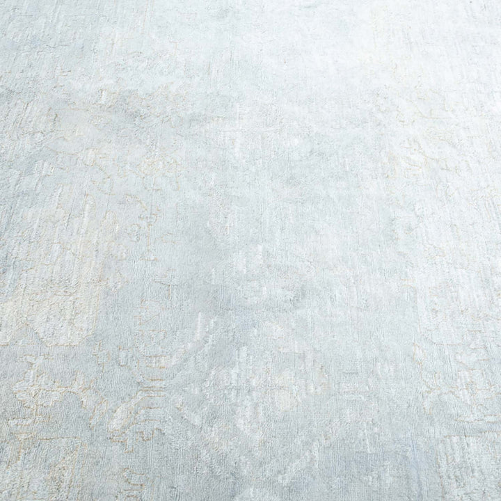 Textured light-colored carpet with subtle faded floral motifs for rustic charm.