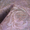 Close-up of a textured fabric in muted purples and pinks.