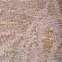 Close-up of a worn, distressed carpet with muted pink tones.