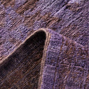 Close-up of textured purple fabric showcases plush and coarse variations.