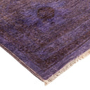 Close-up of a plush purple rug with abstract geometric patterns.