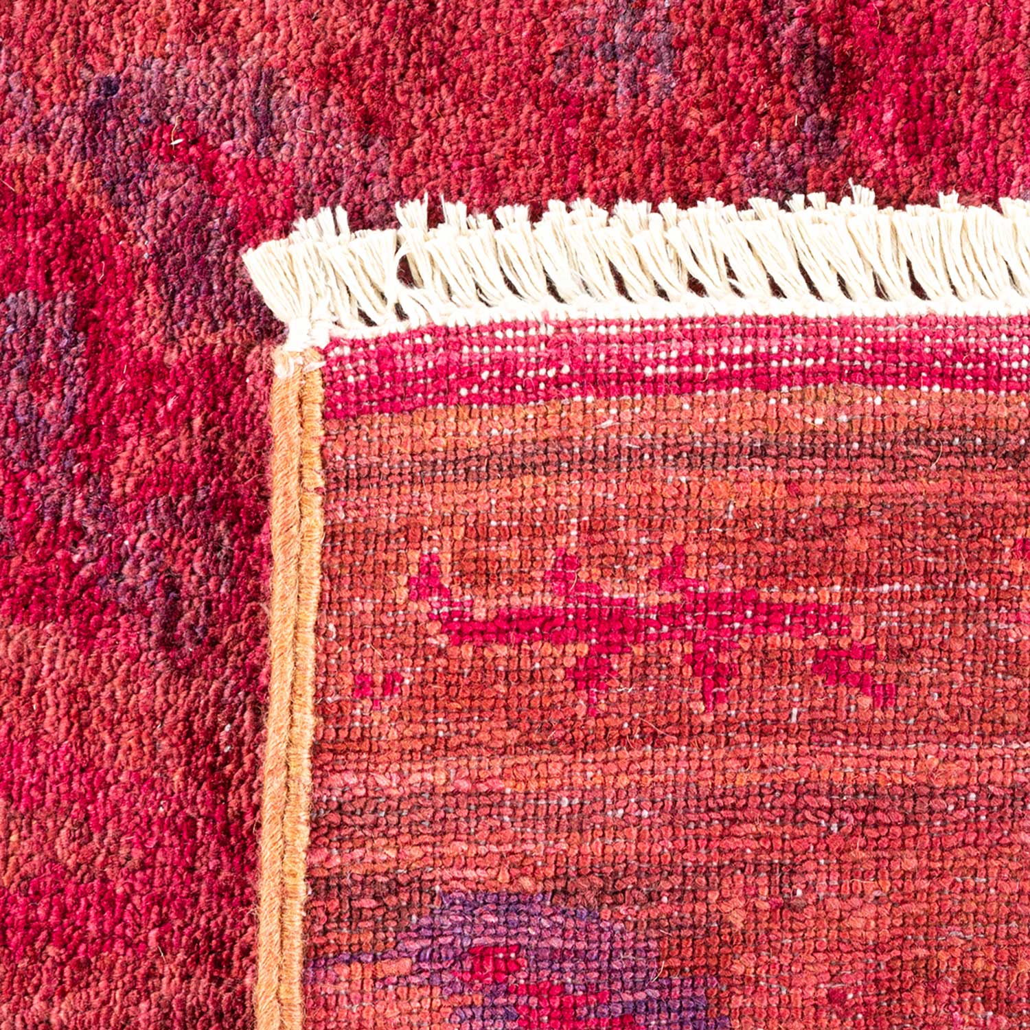 Close-up of a high-quality, handcrafted rug with intricate red patterns