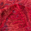 Close-up of a soft, plush, variegated red fabric with texture.