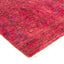 Traditional handwoven crimson rug with textured, mottled appearance and fringe.