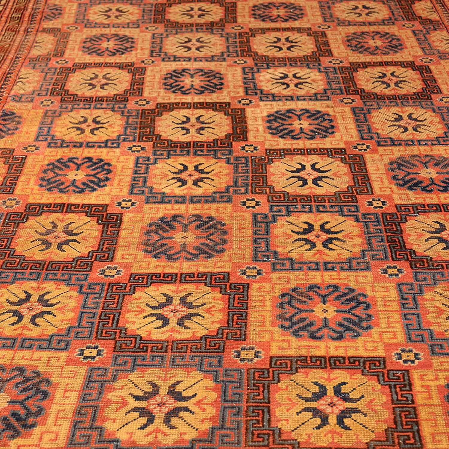 Intricate handwoven rug with geometric motifs in warm-toned colors.