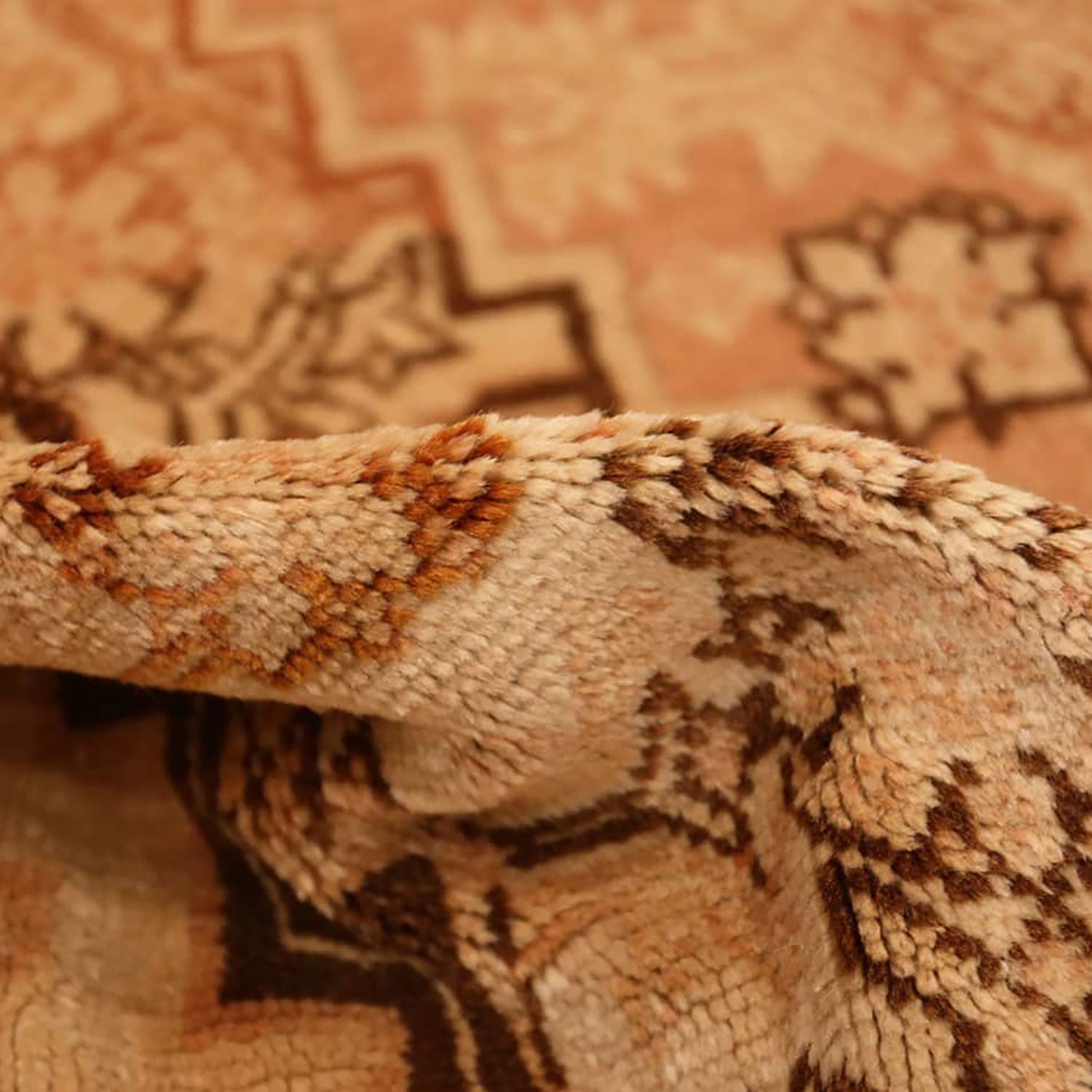 Intricate folded textile with geometric and organic pattern in warm tones.