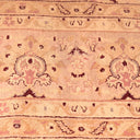 Symmetrical patterned rug in warm peach tone with floral motifs