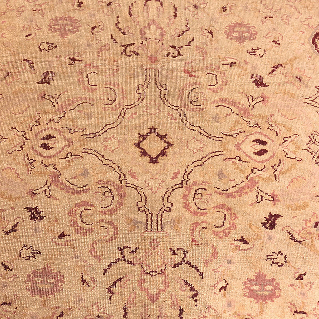 Close-up of a symmetrical, ornamental carpet with muted colors.