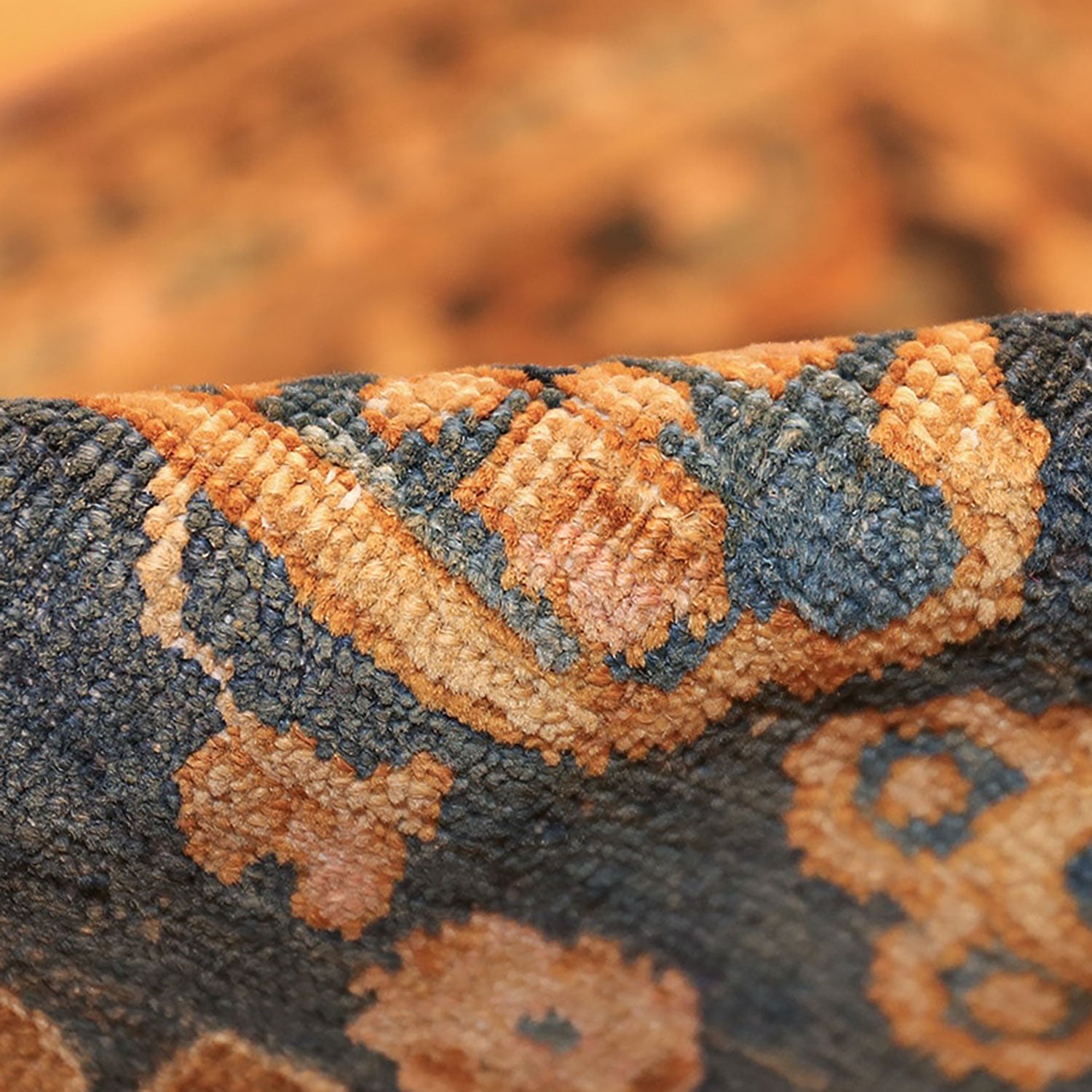 Close-up of textured fabric with orange and blue woven pattern.