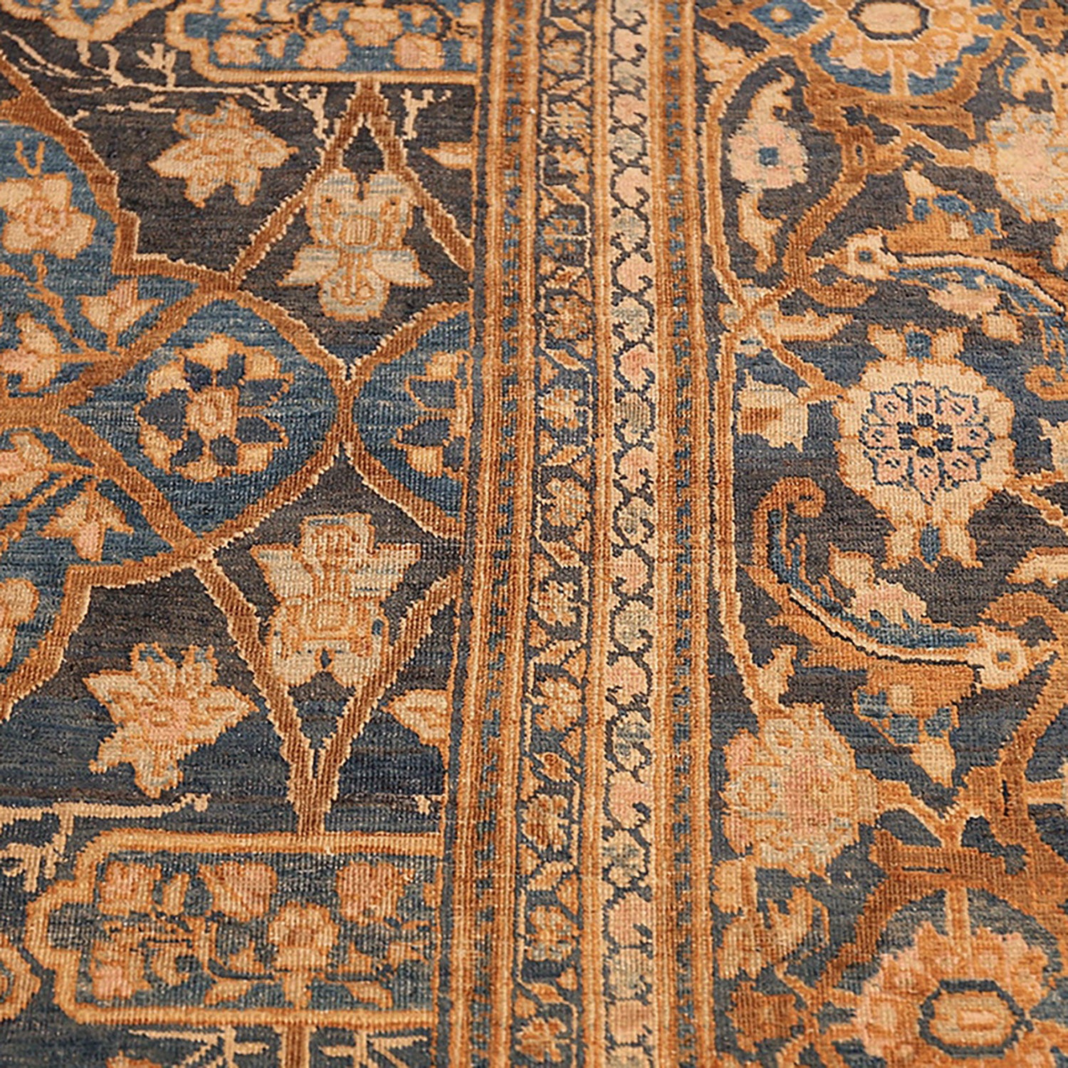 Intricate traditional rug showcases symmetrical motifs in blue, beige, and orange.