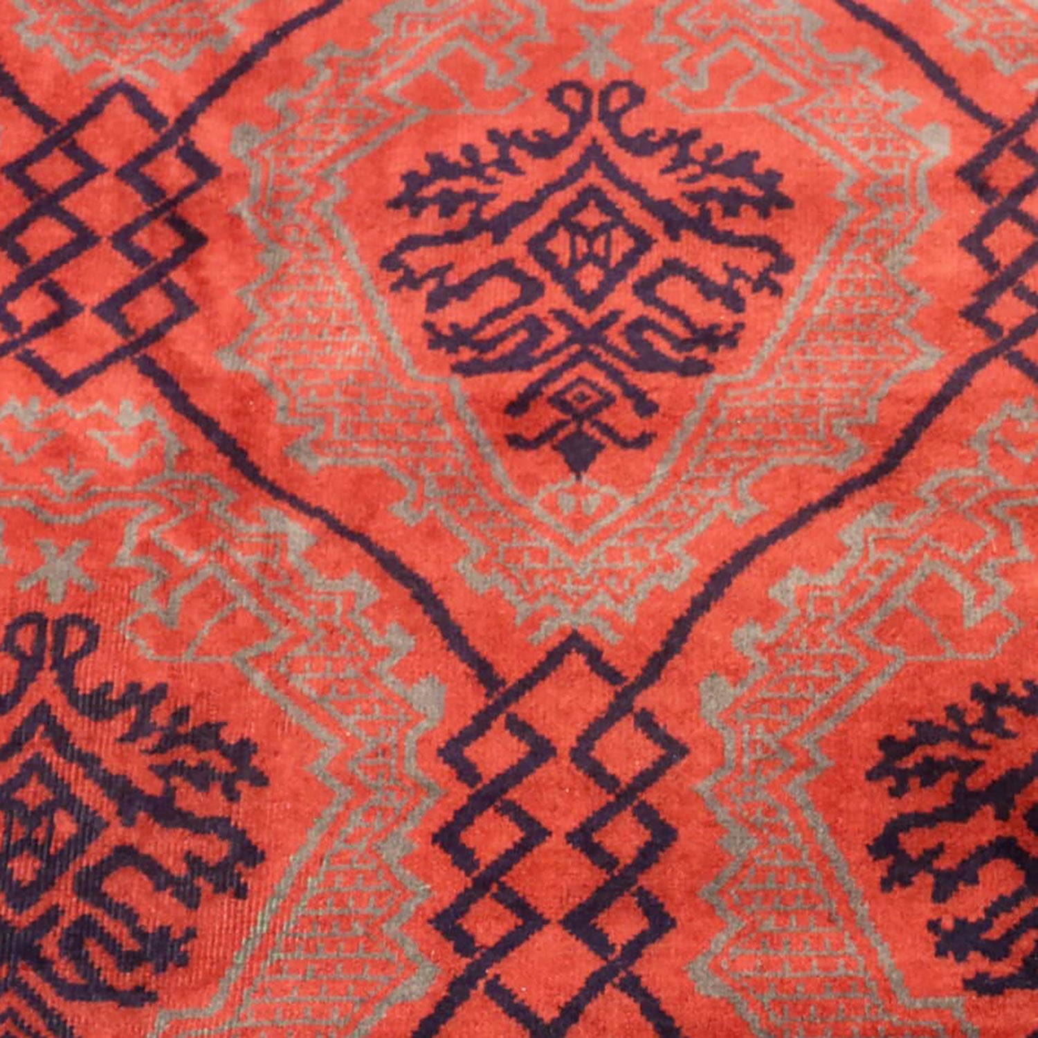 Vibrant Oriental-inspired carpet showcases intricate geometric designs in red and blue.