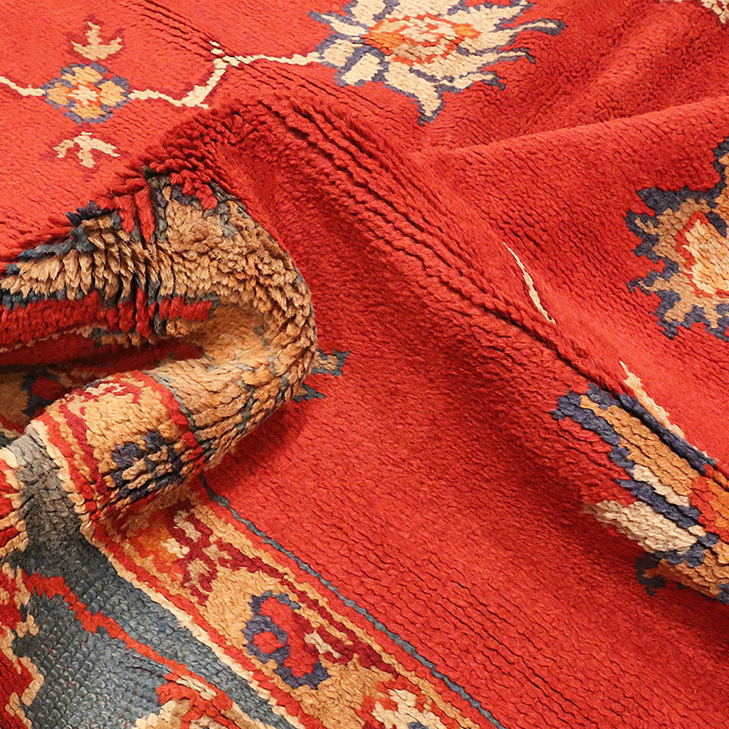 Close-up of a vibrant, worn Oriental rug with intricate patterns.