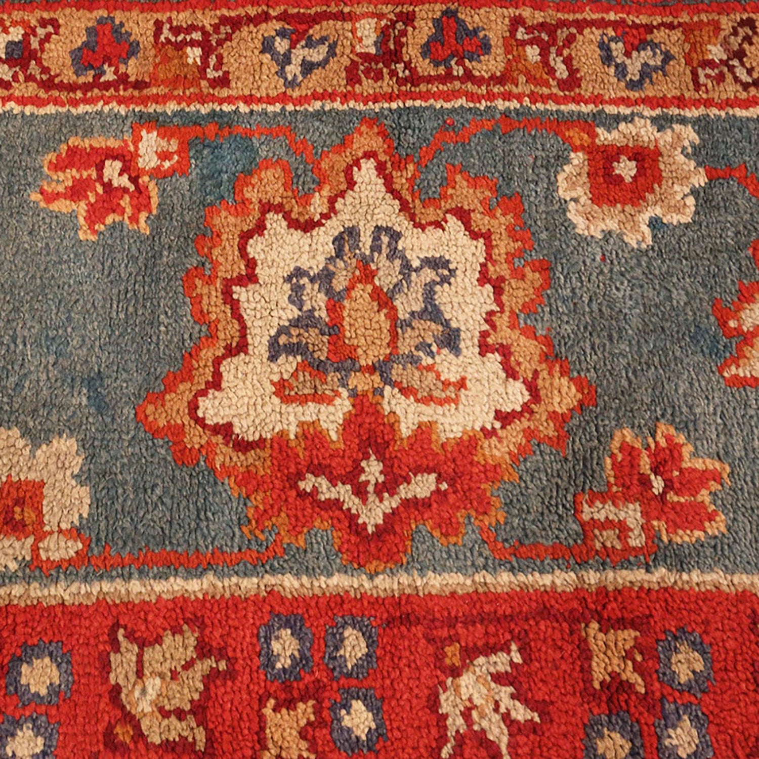 Close-up of a vibrant, well-worn traditional floral patterned carpet.