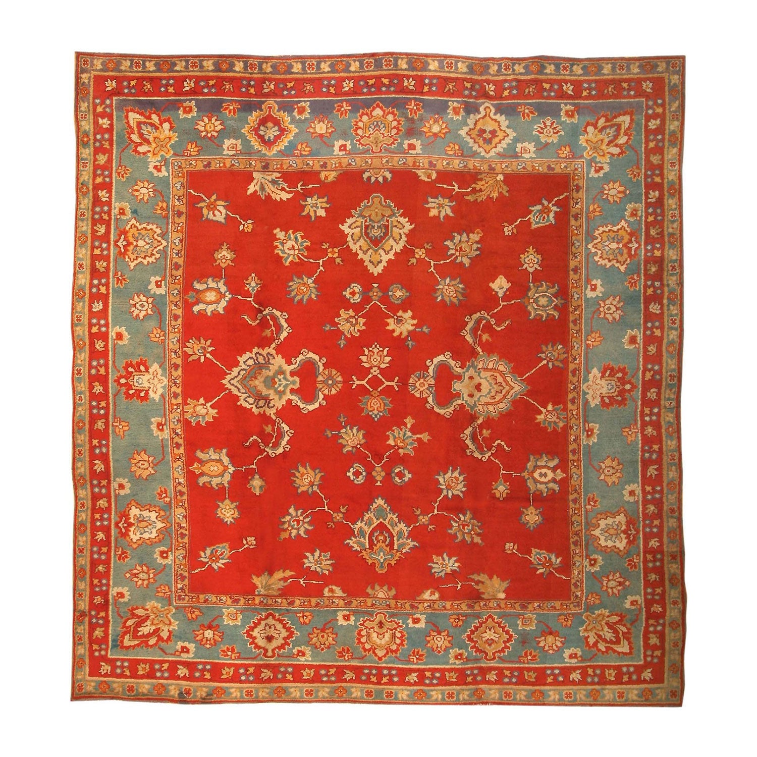 Intricately designed hand-knotted rug showcases rich red floral motifs and intricate patterns on a white background.
