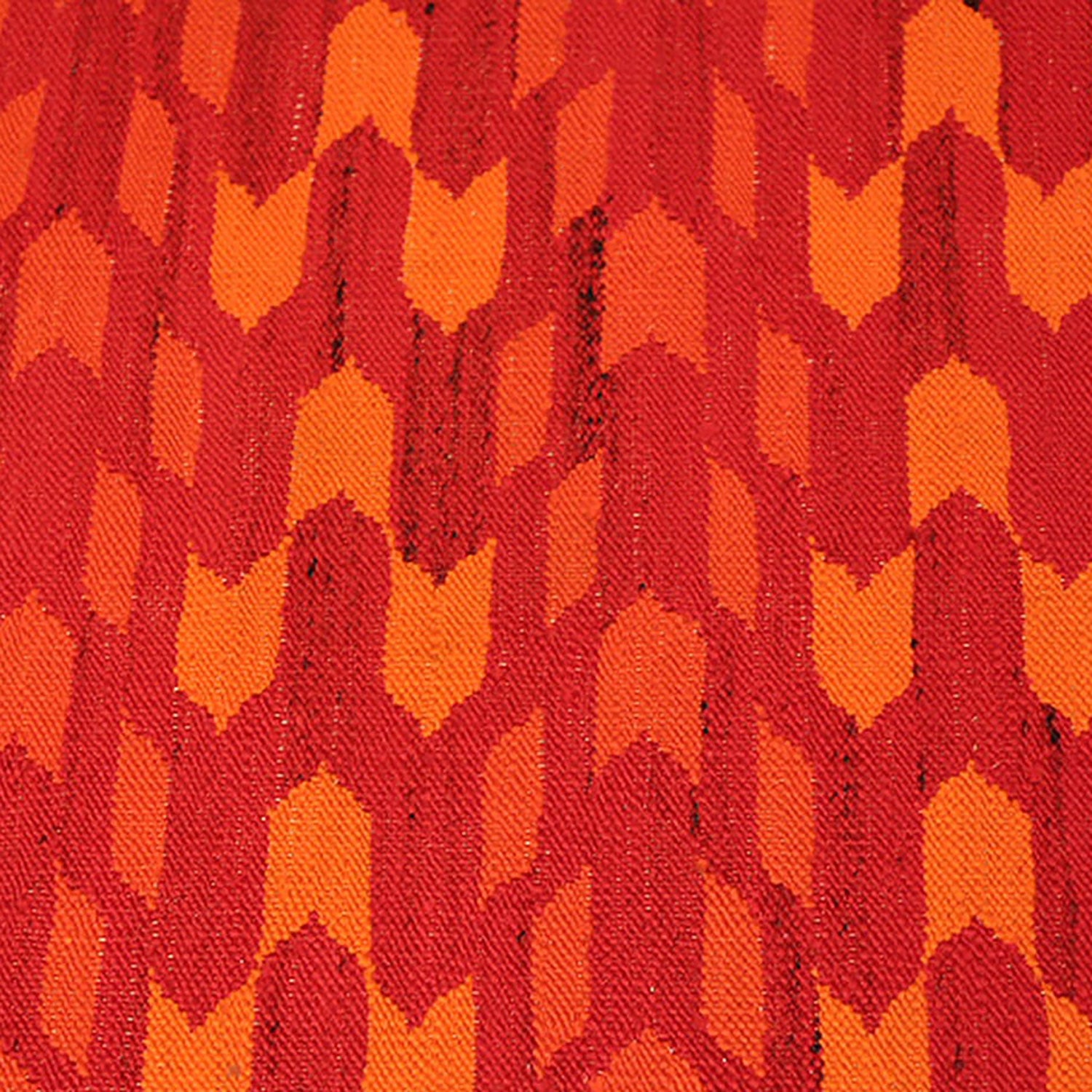 Close-up of plush, zigzag-patterned fabric in red and orange.