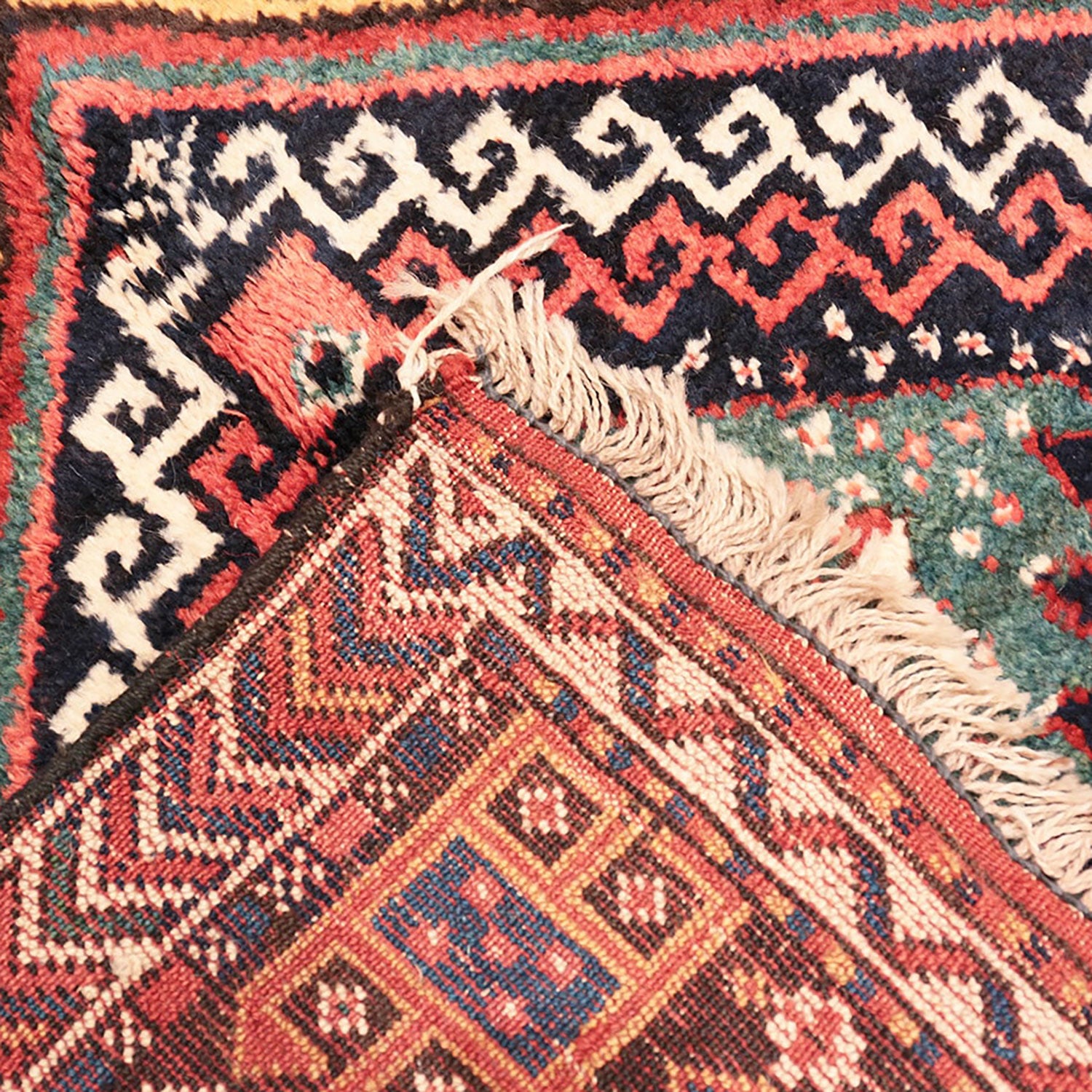 Close-up of handwoven carpet with intricate patterns and rich colors.
