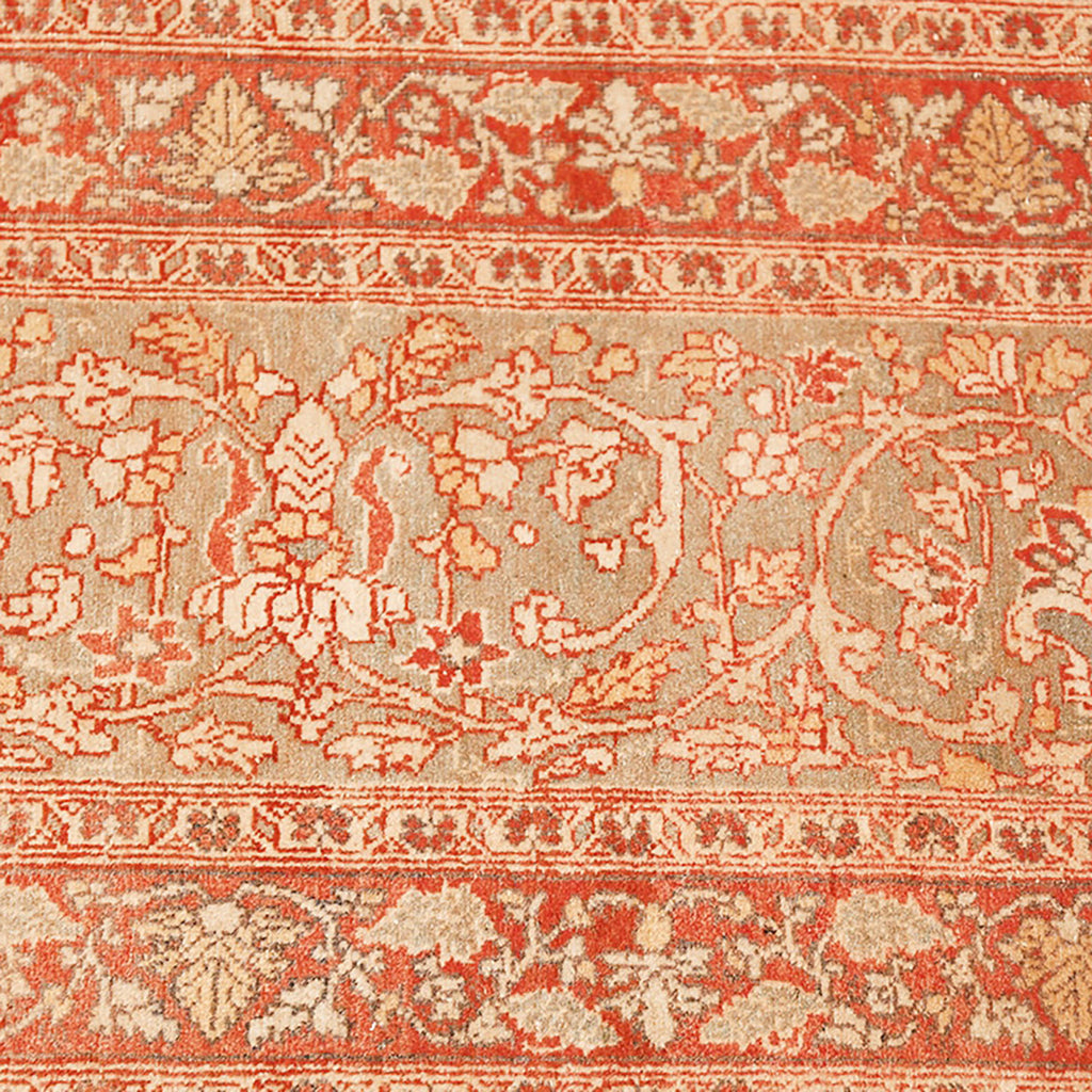 Intricately designed Persian carpet featuring traditional motifs in red and beige.