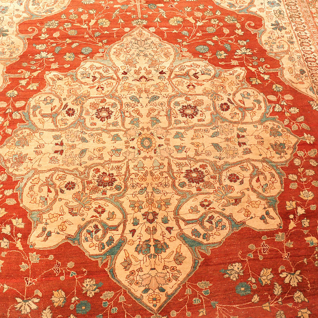 Intricately designed hand-woven rug with rich red background and floral motifs.