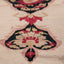 Close-up of a woven carpet with intricate floral pattern.