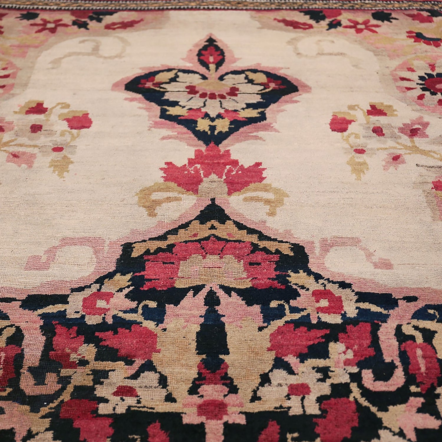 Close-up of an ornate rug with intricate symmetrical patterns.