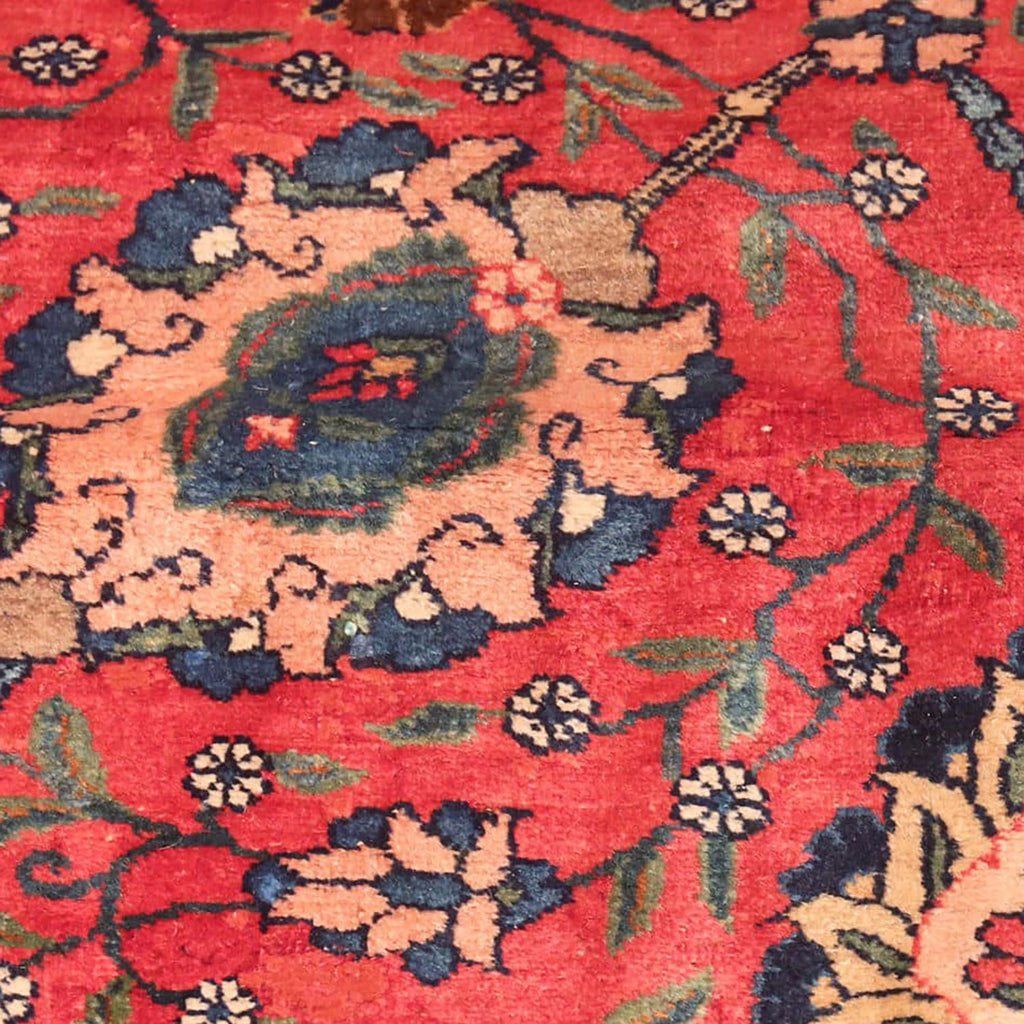 Close-up of a vibrant, worn rug showcasing intricate floral patterns.