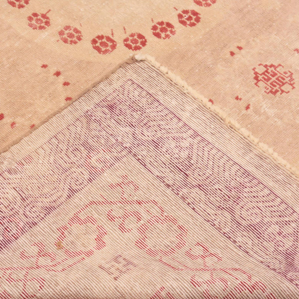 Close-up of fabric with floral and geometric patterns, hand-stitched seam