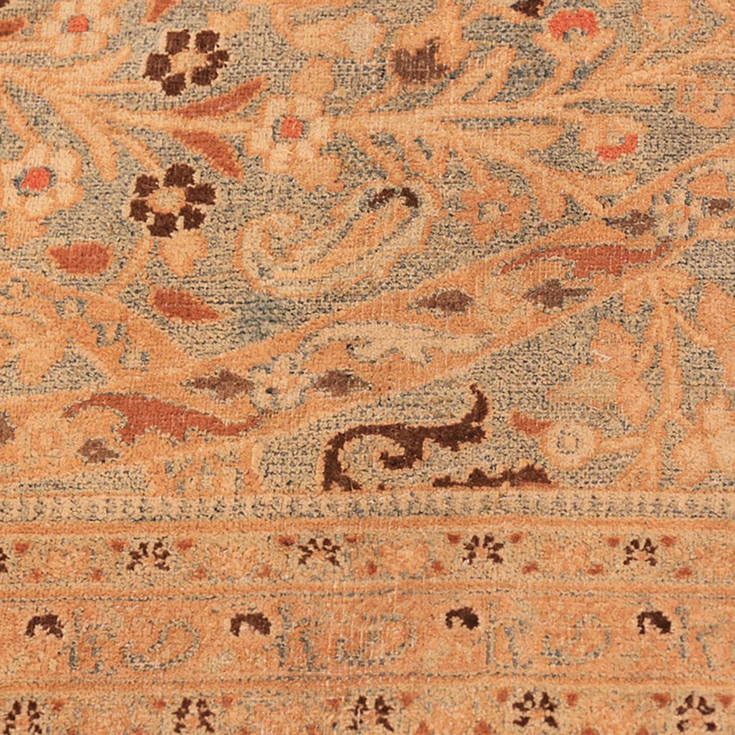 Close-up of a vintage rug with detailed floral motifs.