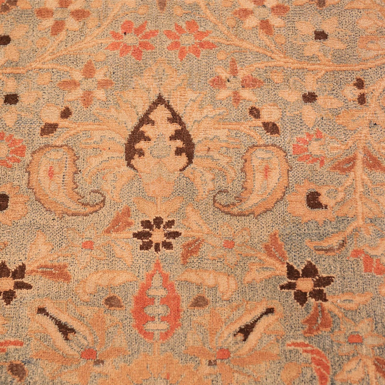 Close-up of well-used traditional rug with intricate floral motifs.