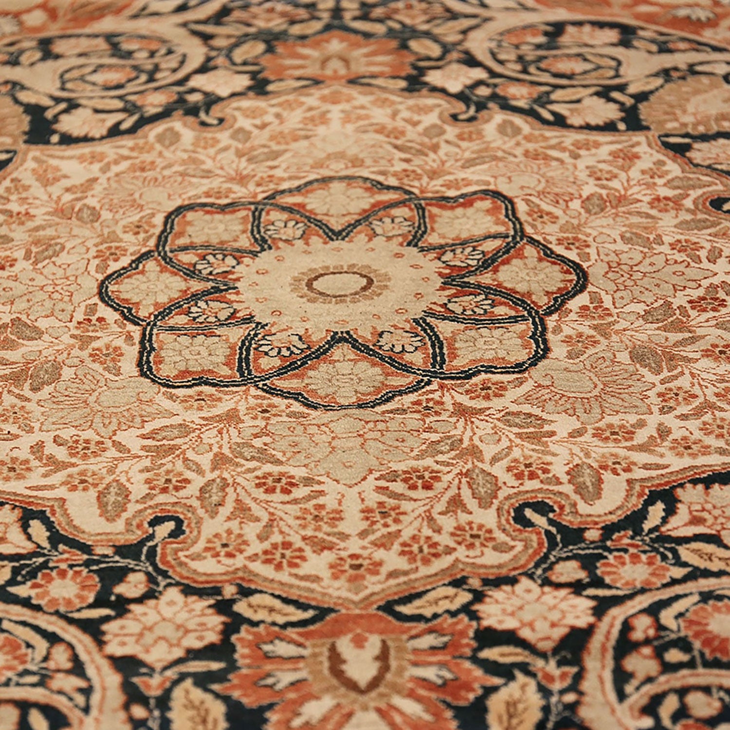 Close-up of an ornate, high-quality handcrafted carpet with floral patterns.