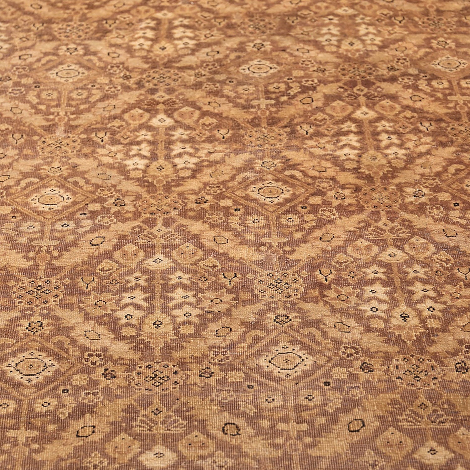 Intricate and symmetrical carpet in earthy tones with Middle Eastern-inspired design.