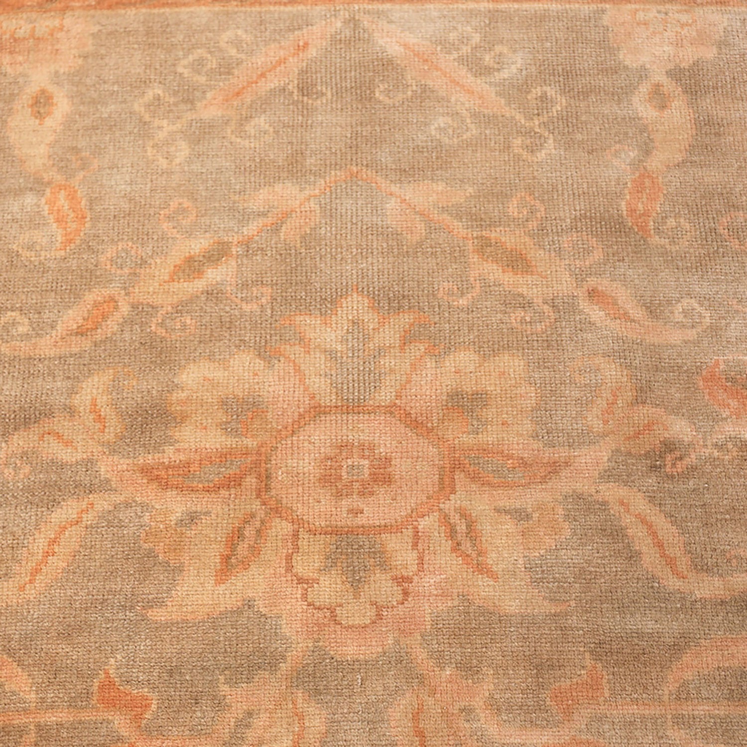 Intricate floral and leaf patterns adorn a woven beige carpet.
