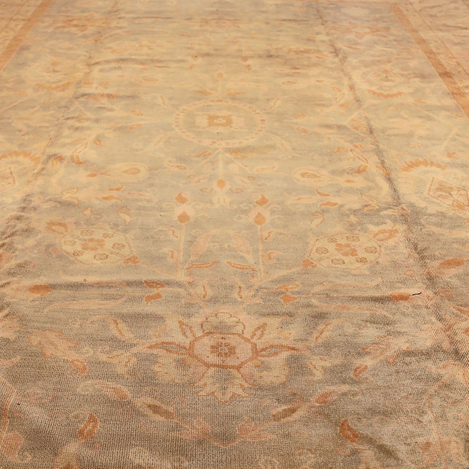 Close-up of vintage floral patterned carpet with subtle colors.