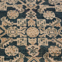 Close-up of a ornate, symmetrical patterned carpet in blue and tan.