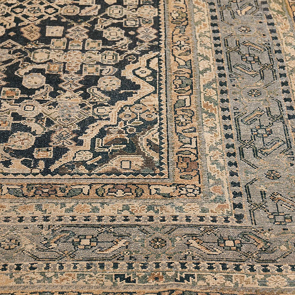 Close-up of vintage rug showcasing intricate geometric patterns and motifs.