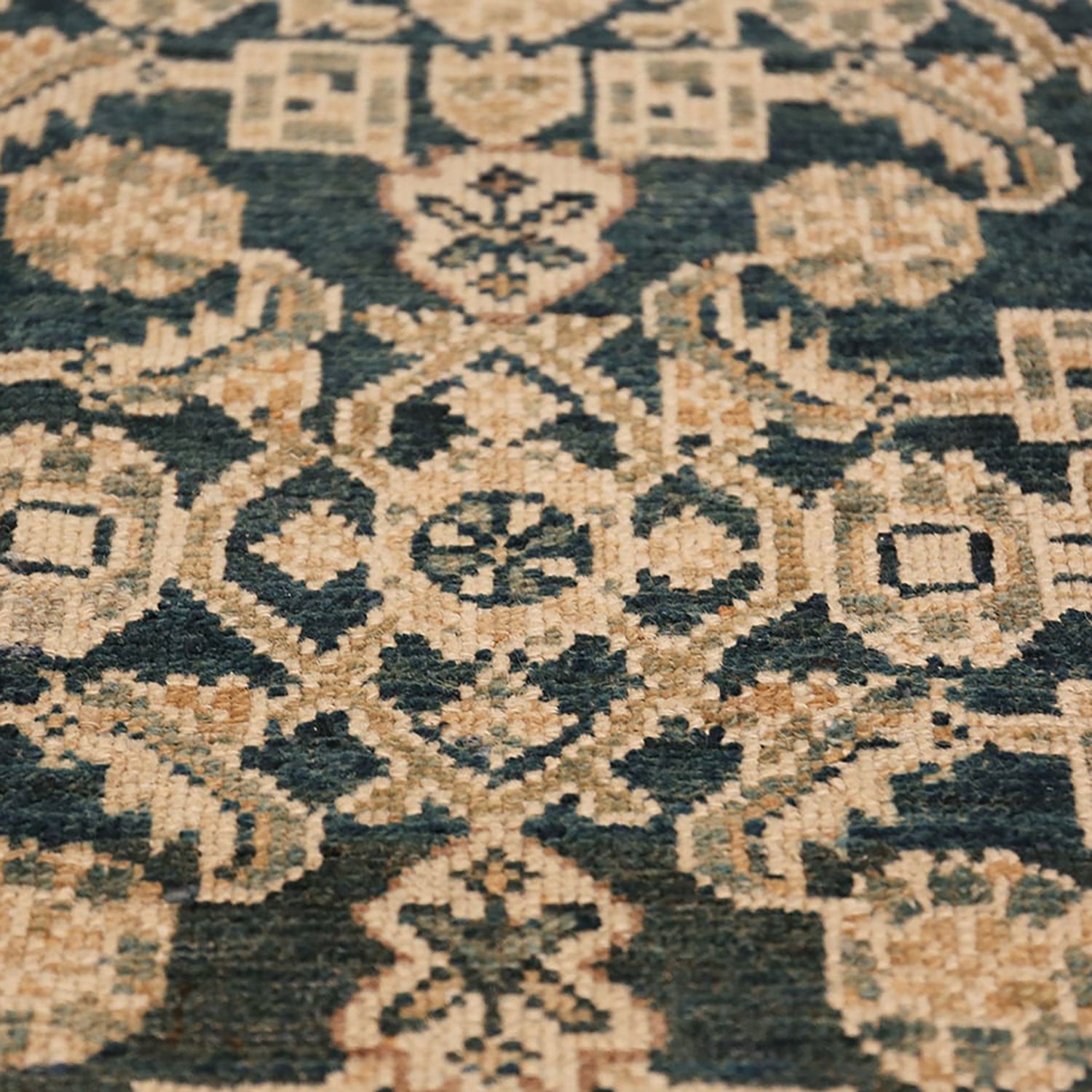 Close-up of a intricate patterned carpet with geometric shapes.