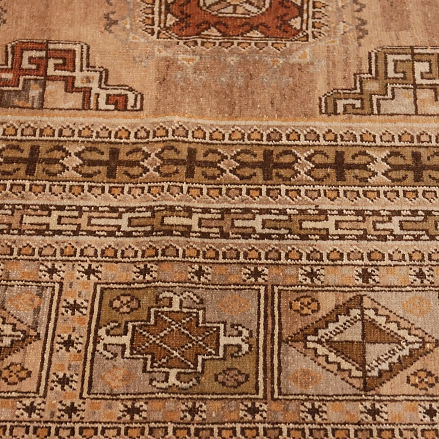 Intricate geometric patterns and earthy tones adorn this traditional rug.