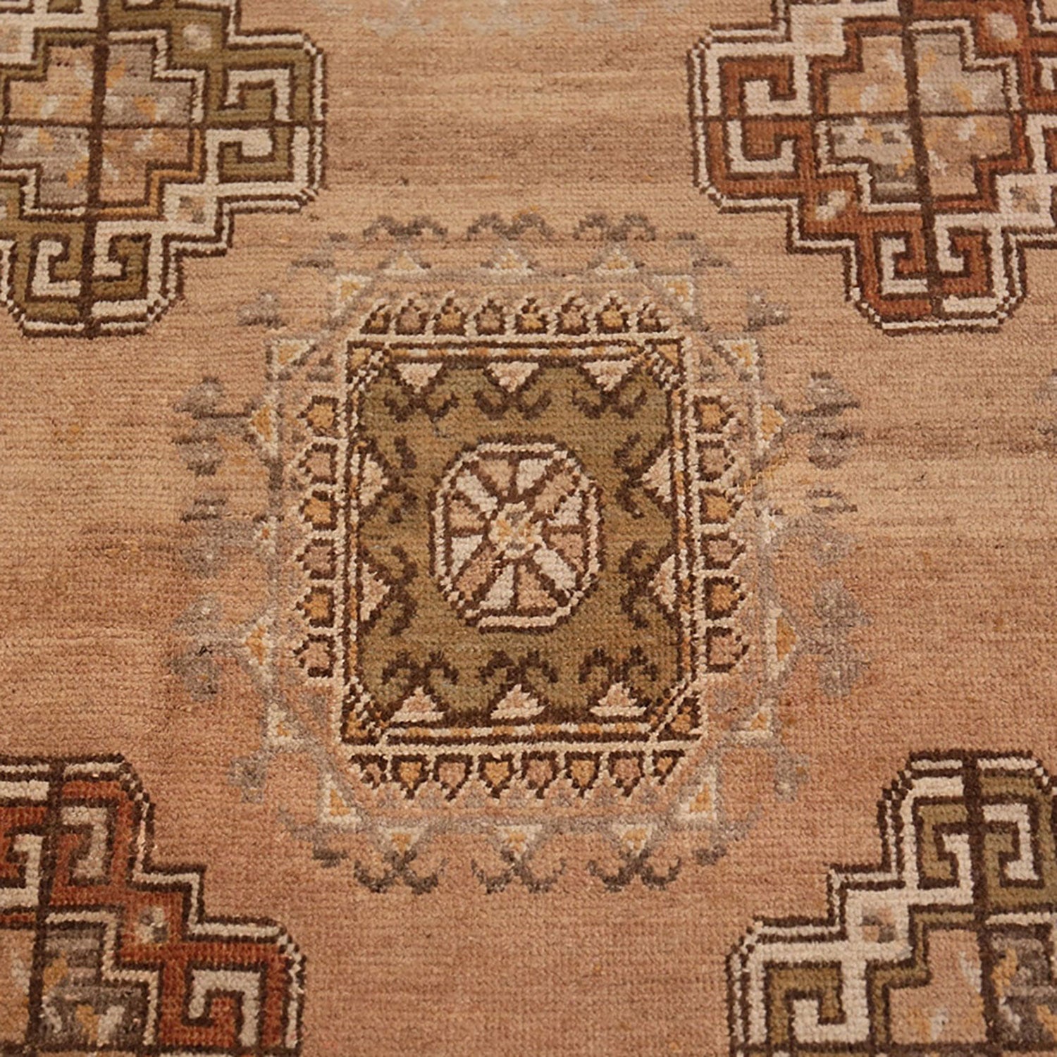 Intricate, symmetrical rug with earthy tones showcases skilled craftsmanship.