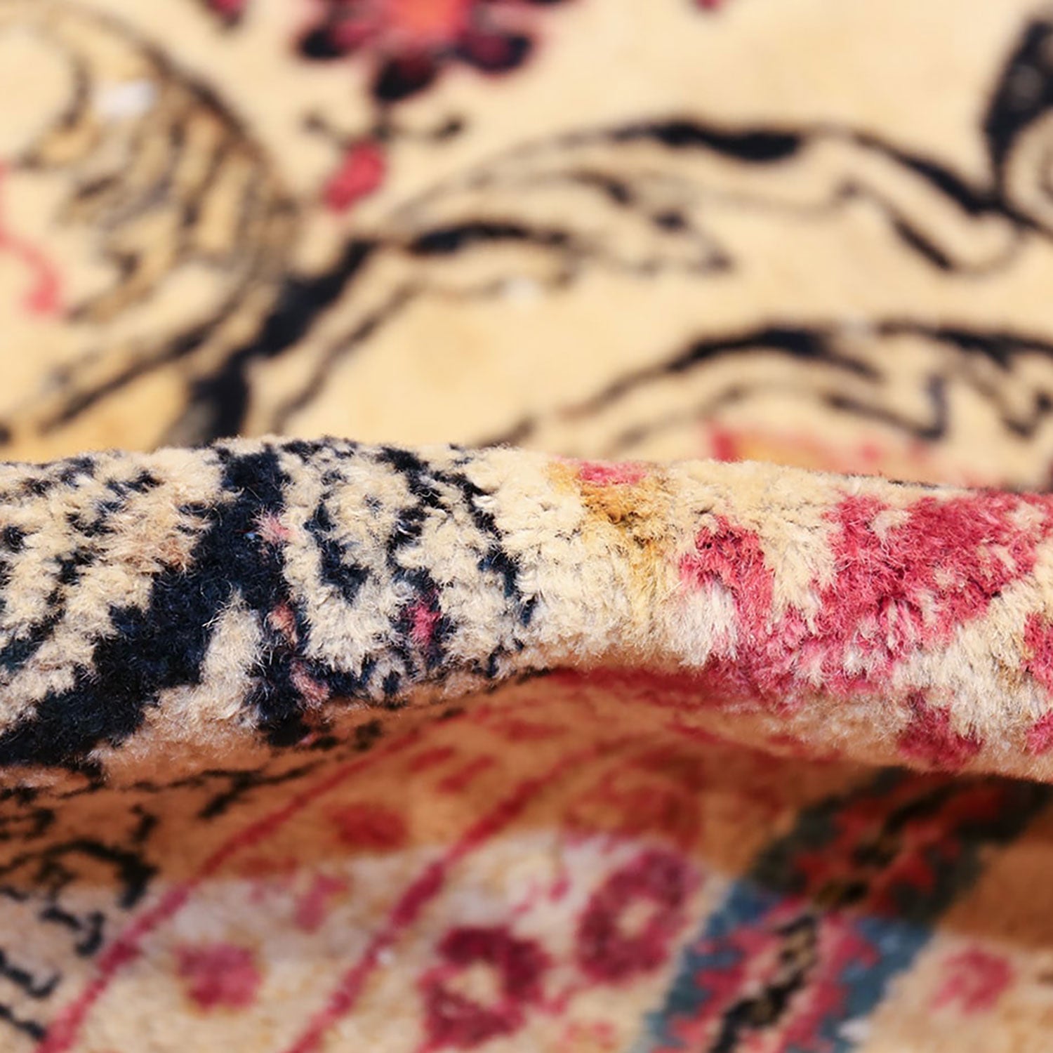 Close-up of patterned carpet displaying intricate designs and vibrant colors.