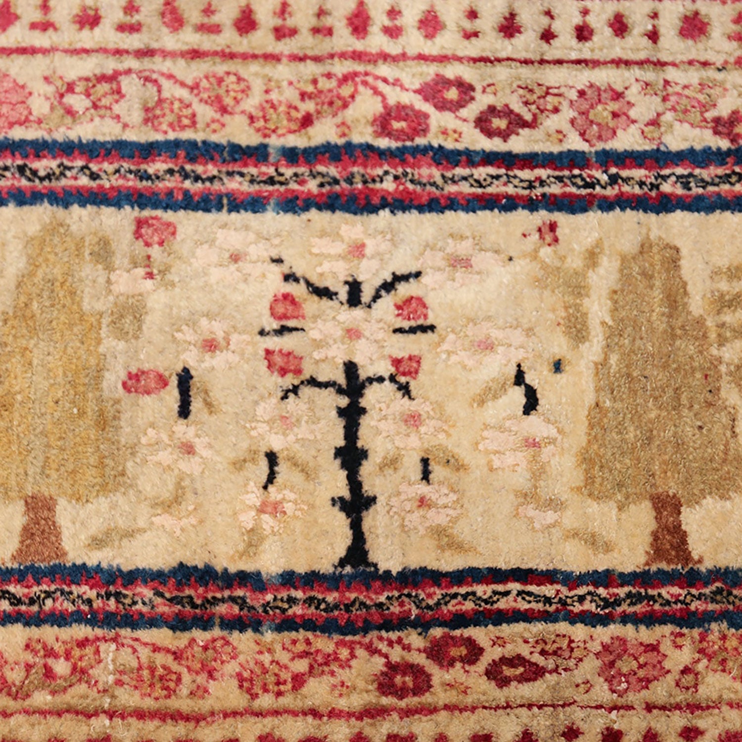 Intricately designed Persian rug with traditional motifs, showing signs of wear.