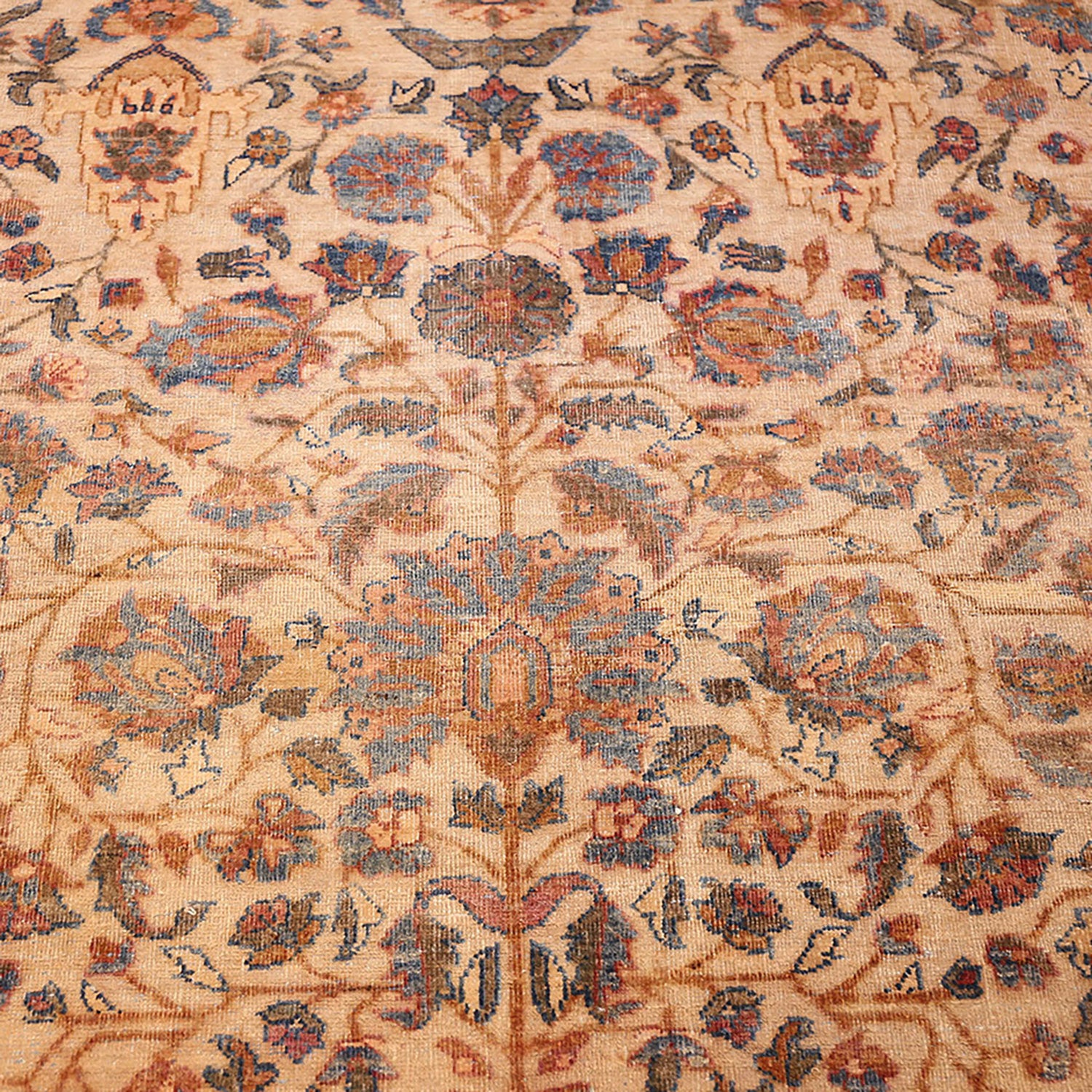 Vintage-style carpet with symmetrical floral motifs in warm, faded colors.