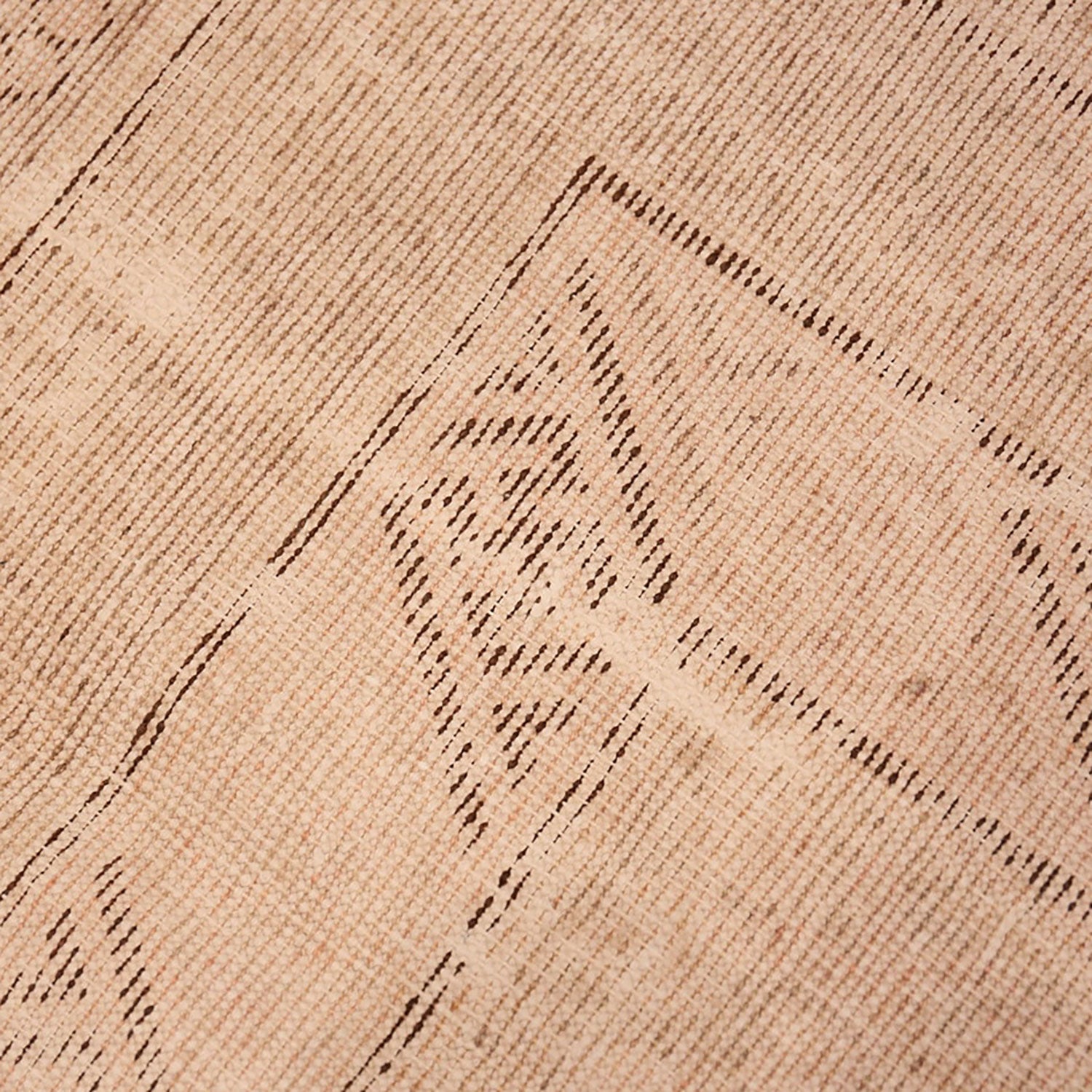 Close-up of fabric with stitched geometric pattern in beige color.