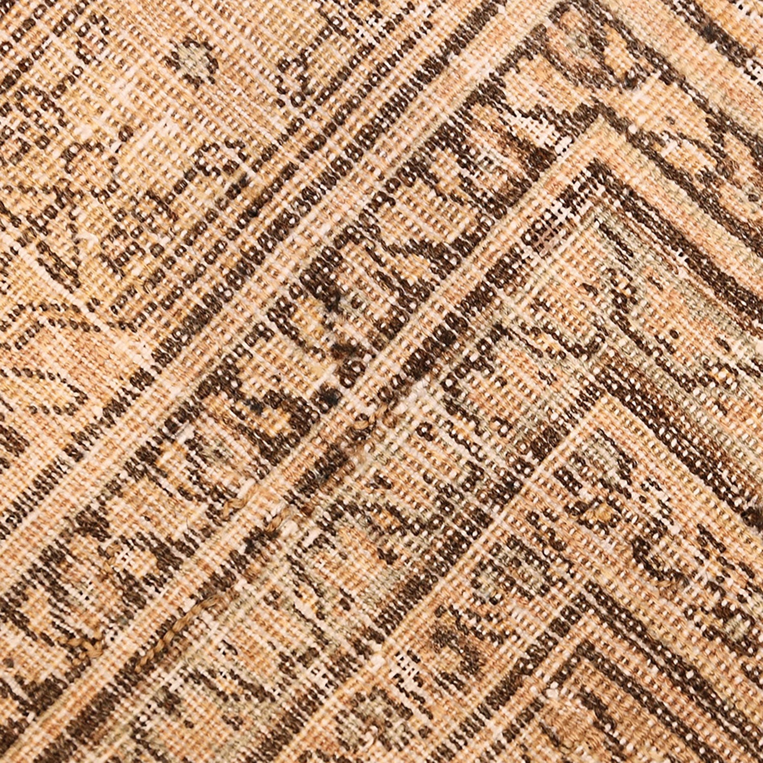 Close-up view of textured fabric with geometric pattern in beige, brown, and cream shades, featuring diagonal lines and horizontal bands creating diamond or zigzag shapes.